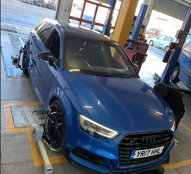 Blue Audi S3 on the 3D wheel alignment ramp at Ignite Autos with alignment sensor heads attached